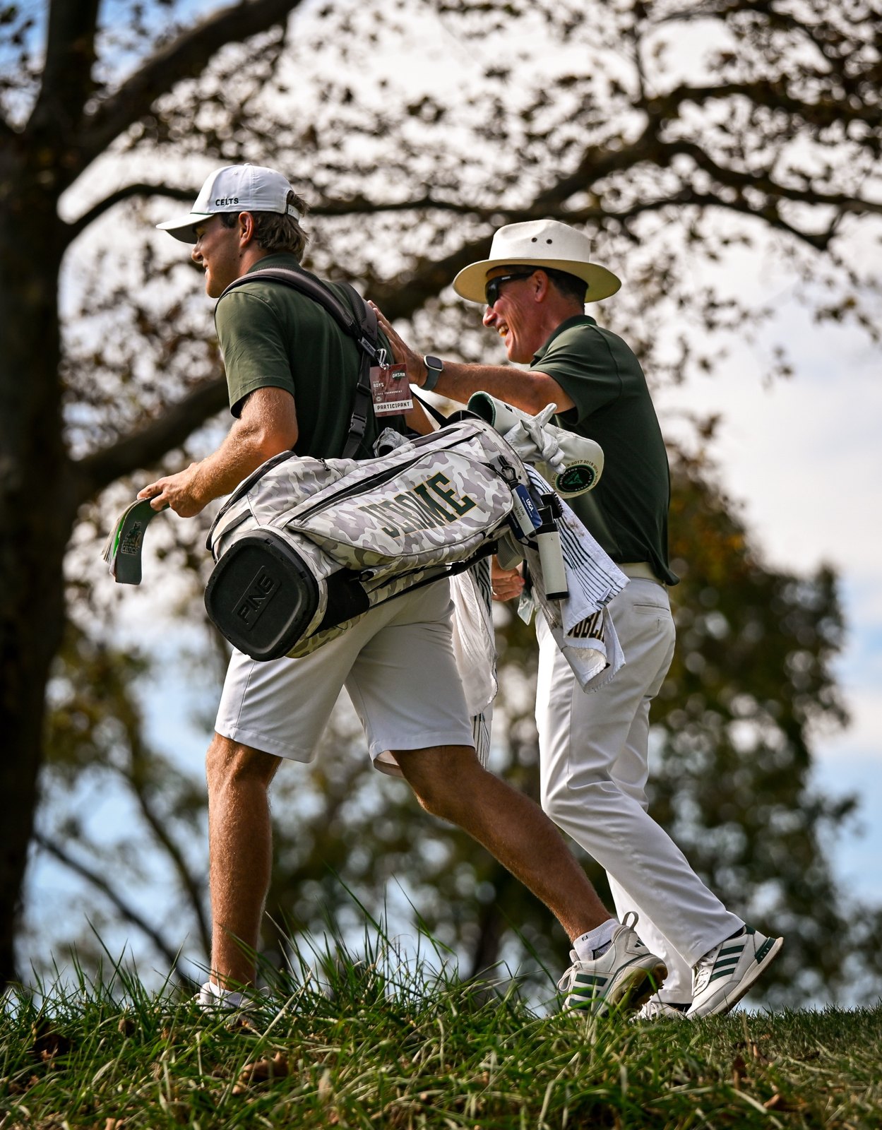 Coach Spar walking off the tee with a player at the state tournament