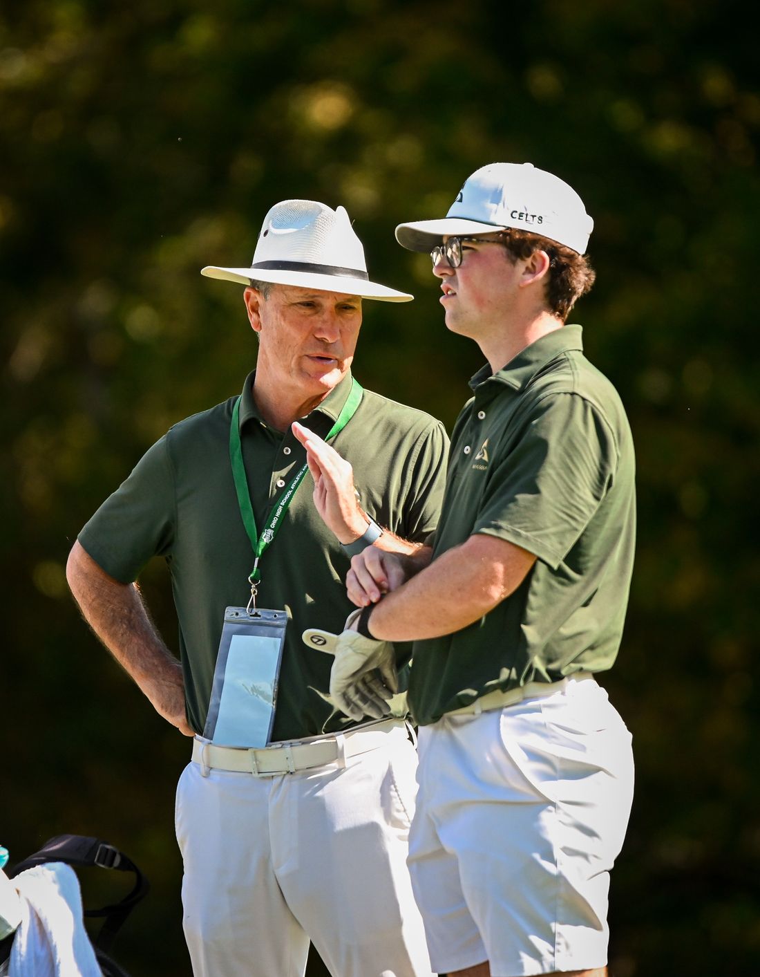 Coach Spar talking with a player on the course